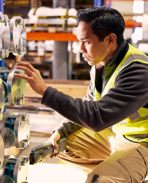 Man crouching down working on machine 