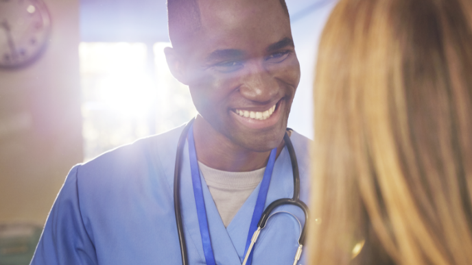 Nurse smiling while interacting with patient 