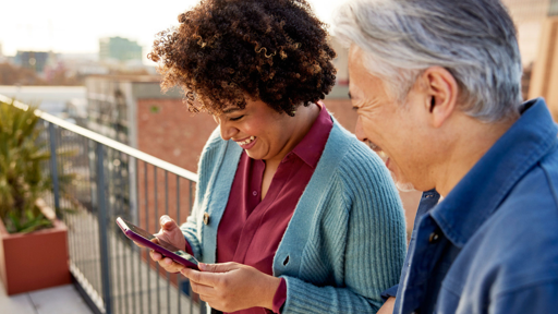 2 people smiling looking at phone