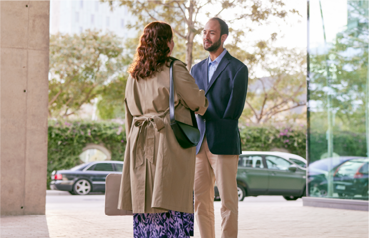 Two people shaking hands outside a building before an interview