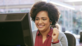 Individual sitting at their desktop smiling