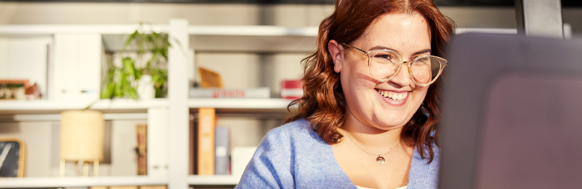 Female in front of computer smiling