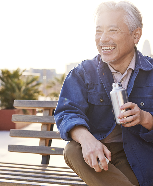 Man smiling sitting on bench with waterbottle