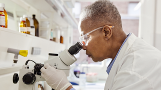 Scientist looking in microscope 