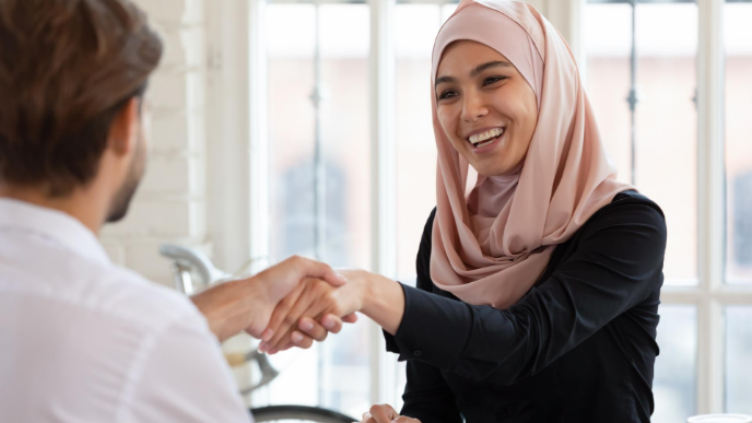 Women in hijab shaking hands 