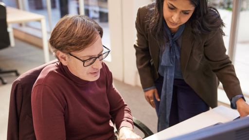 Two people working at office table