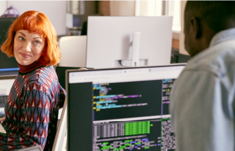 Coworkers smiling while working at computers