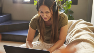 Woman sitting on a sofa looking at a laptop