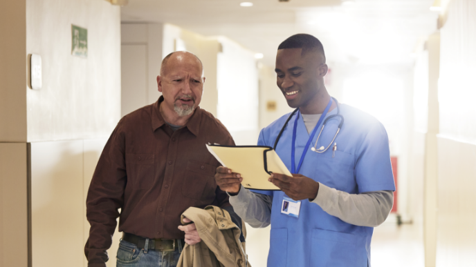 Medical staff reading chart to patient while walking 