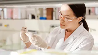 Person working in a lab wearing safety glasses