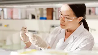 Person working in a lab wearing safety glasses