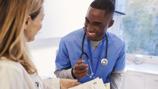 Photo of two healthcare workers talking and smiling 