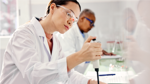 Two people wearing white lab coats working